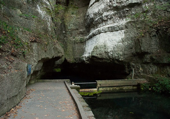 A sidewalk provides a walkway to a large cave opening