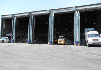 Several trucks loading and unloading waste inside an operating transfer station