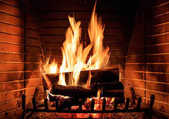 A roaring fire inside a brick fireplace.