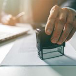 An individual sitting at a desk, data stamping an application form