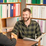 A department employee shaking hands with an individual holding documents