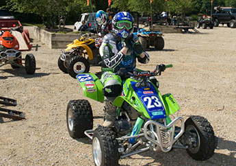 Individuals riding a four wheeler or ORV vehicle in St. Joe State Park wearing a helmet.