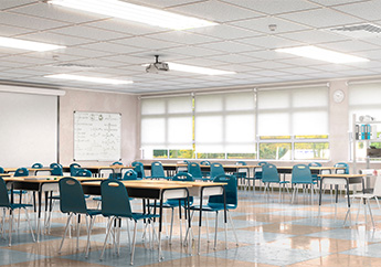 School classrom with desk and chairs. A large window is at the end of the room. A write board is hanging on the wall