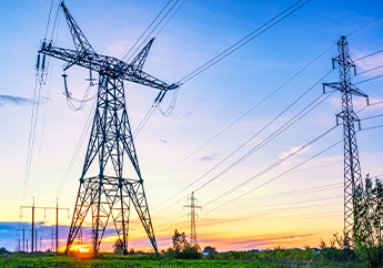 Electric transmission towers and wires in a country setting at sunset