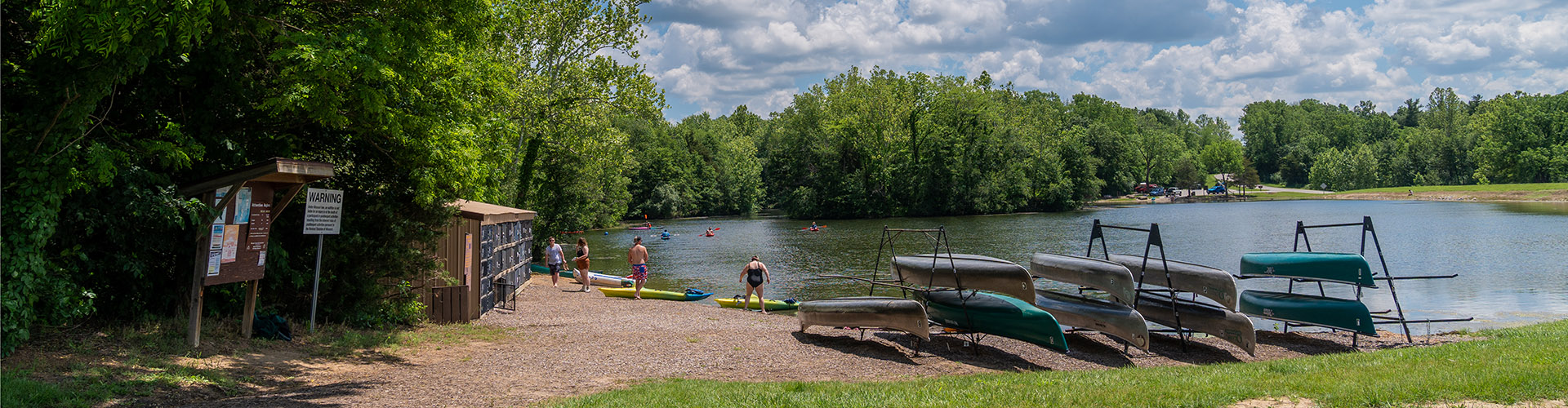 Three canoe racks holding empty canoes on the banks of a Missouri river