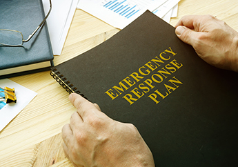 A written emergency response plan on a desk surrounded by other documents