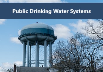 A water tower holding drinking water sits high above residential homes 