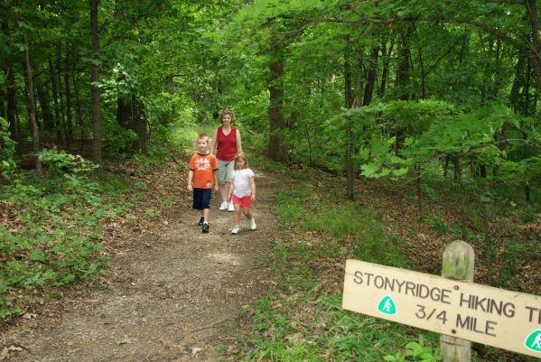 Young boy and girl, followed by their mother walk a trail at Bothwell Lodge State Historic Site.