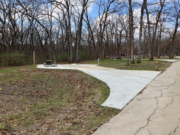Concrete pad for parking campers and picnic table is on the left side of the pad.