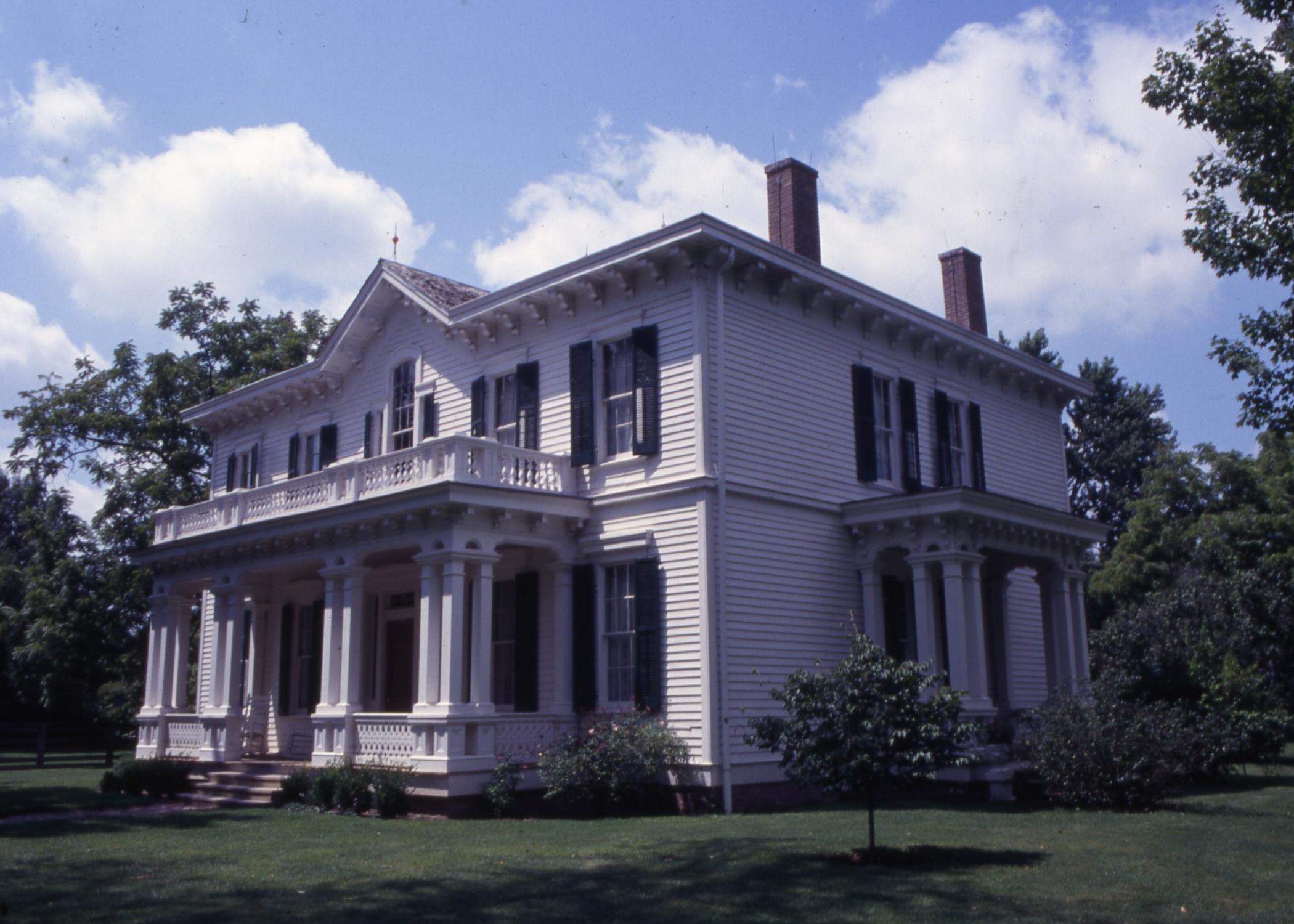 White two-story mansion with two chimneys on roof.