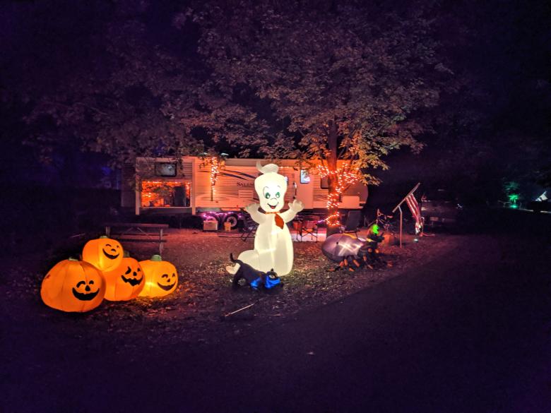 Halloween scene in front of a camper with four blow-up pumpkins and one blow-up Casper the Friendly Ghost figure 