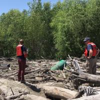Environmental emergency response and EPA investigate flood debris for orphaned containers.