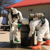 Environmental emergency response staff training on patching a leaking drum.