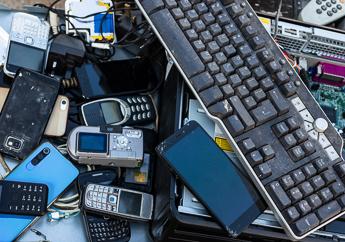 A pile of discarded computer keyboards, mice, cell phones and tablets