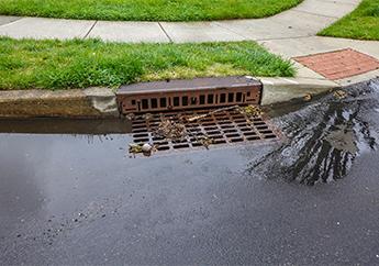 stormwater running into storm drain on a road