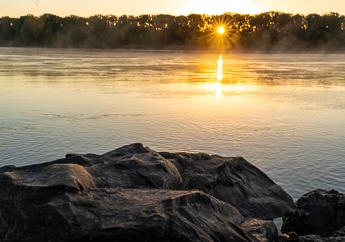Sunrise barely peeking through a distant tree line at the Marion Access to the Missouri River