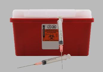 Syringes in front of a red biohazard sharps disposal container.