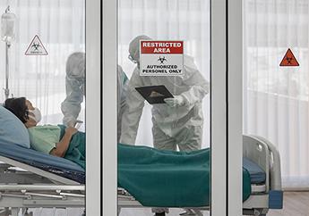 Patient in a quarantine room at a hospital, with quarantine and outbreak alert signs, being cared for by disease control experts