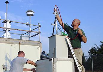 Department staff member checking an air monitoring station in Liberty.