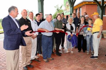 Officials gather to cut a ribbon to celebrate the opening of a trail corridor in Sedalia