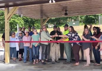 officials gather to cut a ribbon to celebrate the opening of a fish cleaning station in Roaring River State Park