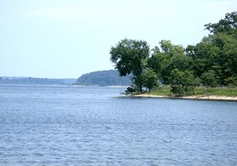 Truman Lake waterway with green land and trees in the background