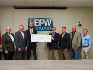Division of Energy director Craig Redmon hands a Municipal Utility Emergency Loan Program big check for $750,000 to members of the Hannibal Board of Public Works.