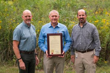 photo of Mike Sutherland, deputy director of Missouri Department of Natural Resources, Joe Gillman, director of the Missouri Geological Survey division holding the Governor's proclamation and Dru Buntin, director of the Missouri Department of Natural Resources.