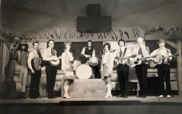 The Pomme de Terre Opry with Kenneth Pitts dressed as his character Herman Sneezleweed is picture holding the bass once belonging to Lee Mace.