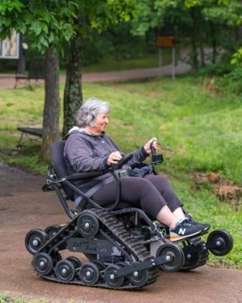 Woman smiles while navigating the trail at Elephant Rocks State Park using Action Trackchair