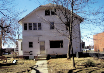 Before photo is a white, three-story house with a small porch and sidewalk leading to a door
