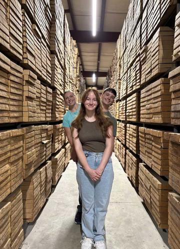 Arden Fraley, Abby Trachsel, and Luke Crutchfield standing among boxes of rock core and cuttings at the department's McCracken Core Library
