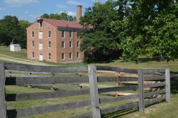 Watkins Mill red brick building and wooden fence in the foreground