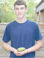 Samuel Angst holding the winning pawpaw in Bennett Spring State Park’s 4th annual Paw Paw contest